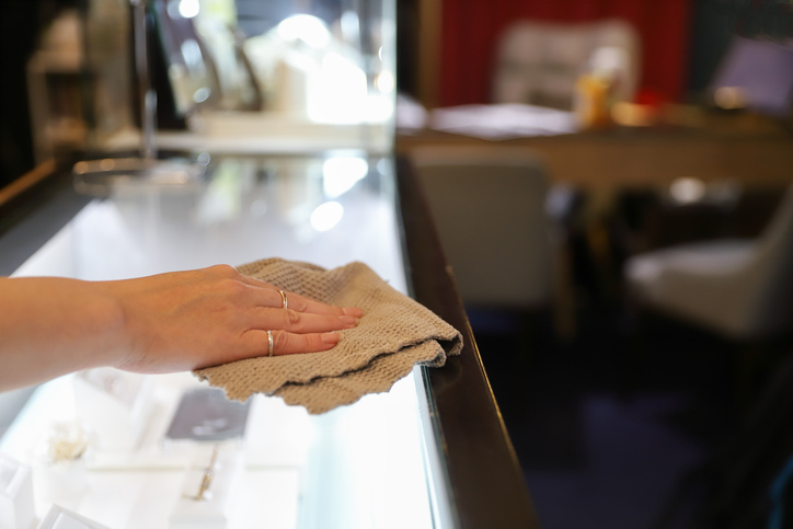 Sorgfältige Reinigung einer Glasvitrine in einer Münchner Luxusboutique, um Staub und Schlieren zu entfernen und den Werterhalt zu sichern.