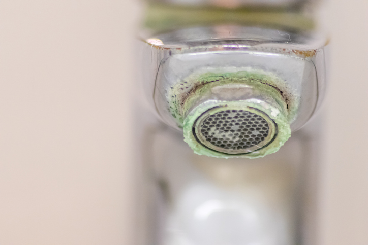 Verkalkter Wasserhahn mit stark verschmutztem Perlator und sichtbaren Kalkablagerungen am Strahlregler