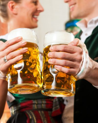 Mehr Freizeit in München dank professioneller Reinigung Paar in Tracht genießt die schönen Seiten Münchens mit einem Maßkrug Bier – die gewonnene Freizeit durch den Reinigungsservice der Schlueter Group.