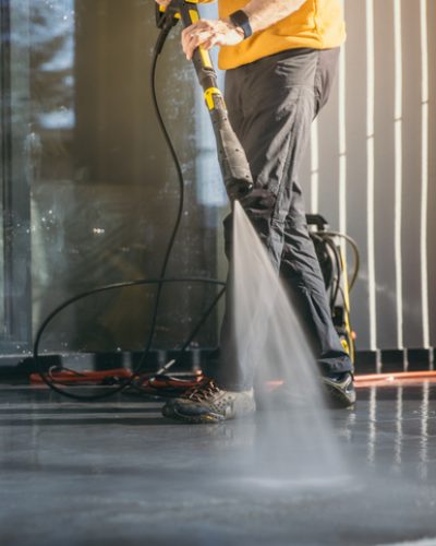 Professionelle Spezialreinigung in München | Schlueter Group Geschulte Fachkraft der Schlueter Group bei der professionellen Terrassenreinigung mit einem Hochdruckreiniger in München.
